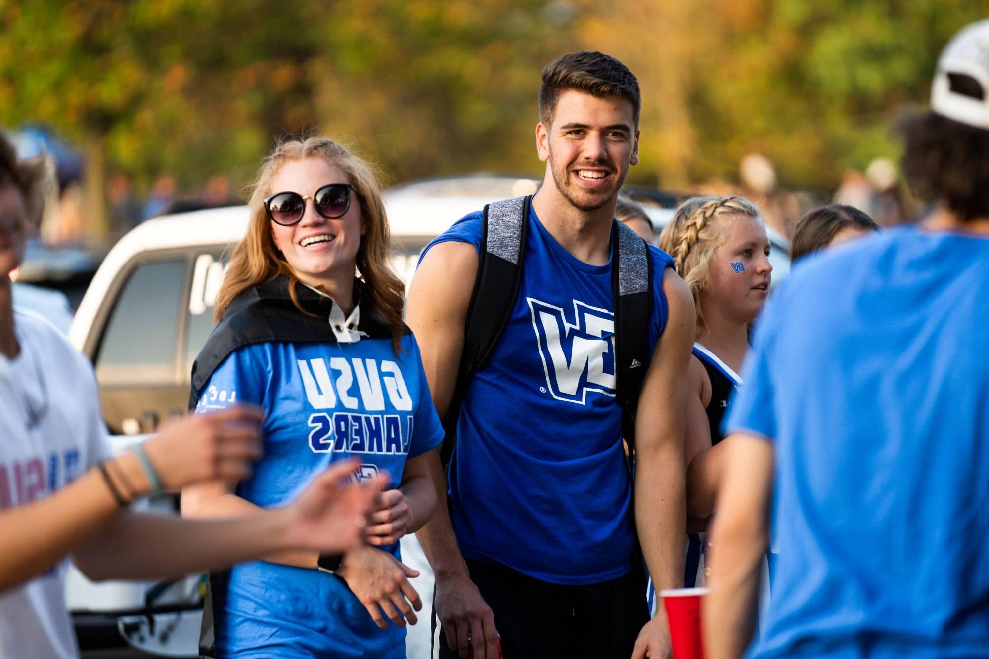 Students smile wearing GVSU gear before a football game